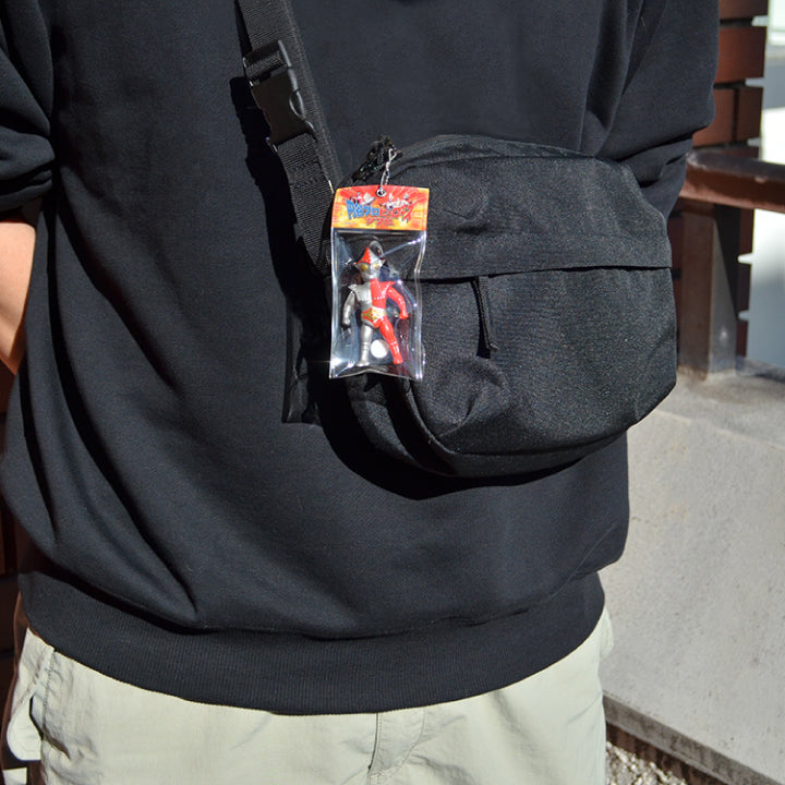 Jamborg 9 sofubi ball-chain mascot attached to a black crossbody bag