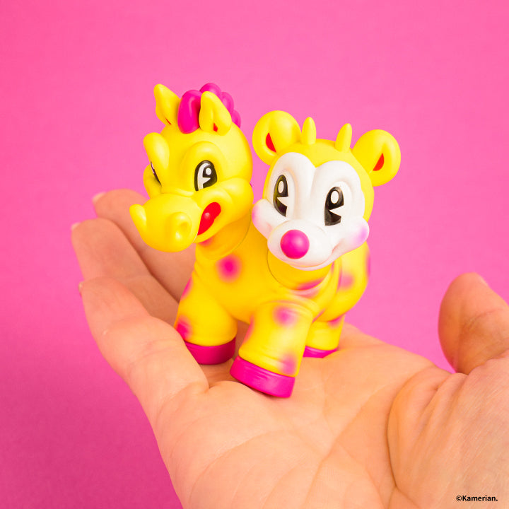 Yellow UMASHIKA figure held in a hand to show its approximately 62 mm size