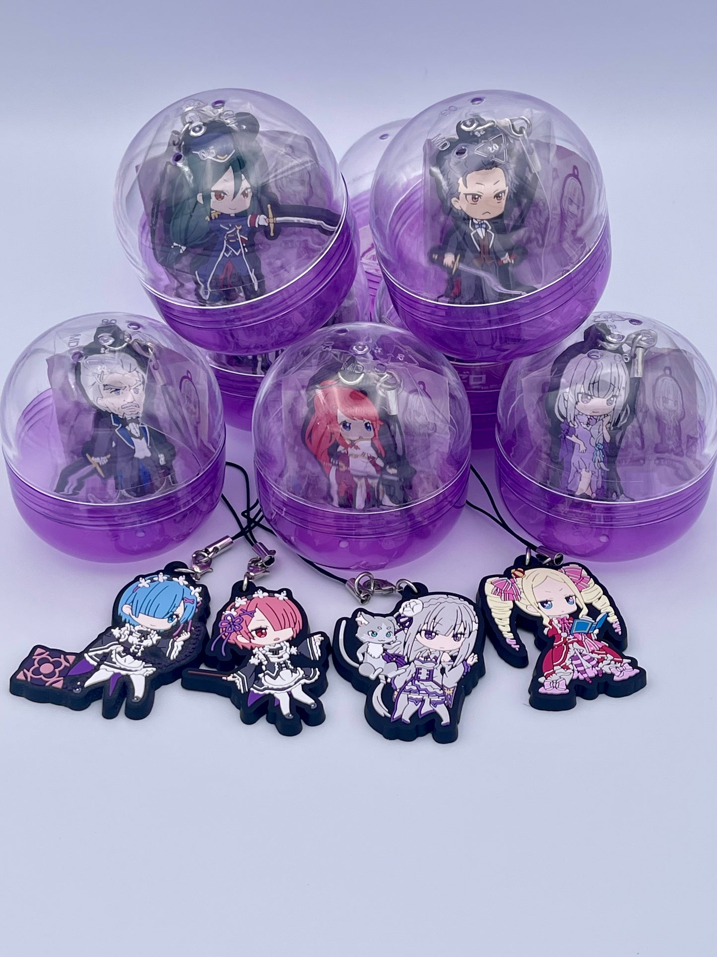 Re:ZERO gachapon capsule packaging - authentic Japanese collectible showing Emilia, Rem, Ram, and Beatrice. Additional 5 characters are also seen in background in purple capsules.
