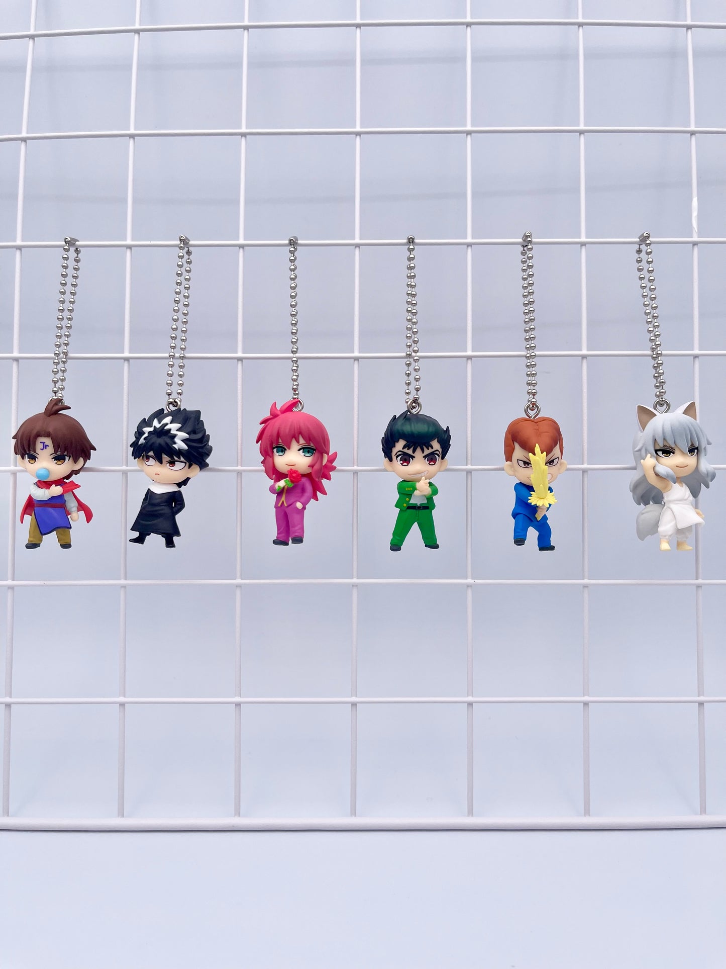 Set of Yuyu Hakusho mini figure keychains  featuring Yusuke Urameshi, Kazuma Kuwabara, Hiei, Youko Kurama, Koenma. Figures are displayed on a wire grid.